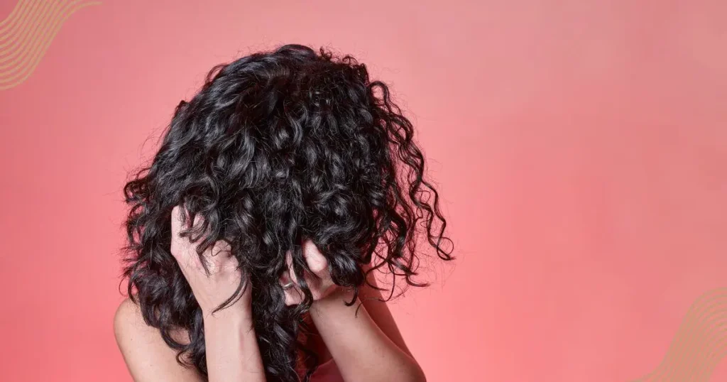 young black curly haired women combing her hair -How to Know If Your Hair Needs Protein